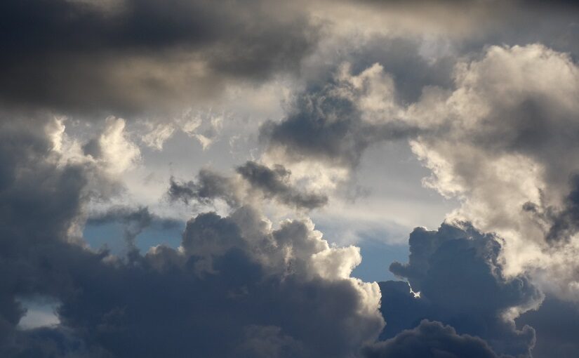 Light and dark clouds swirled against blue sky