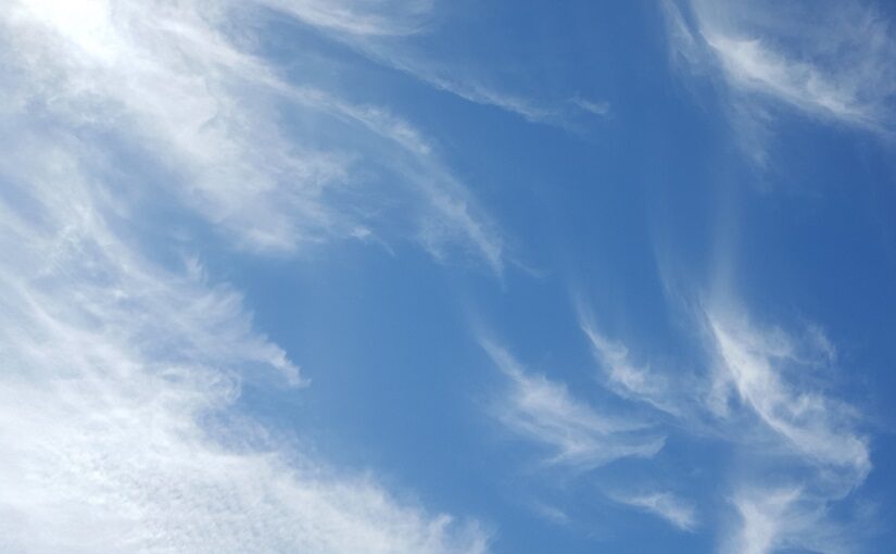 Wispy clouds stretching across blue sky