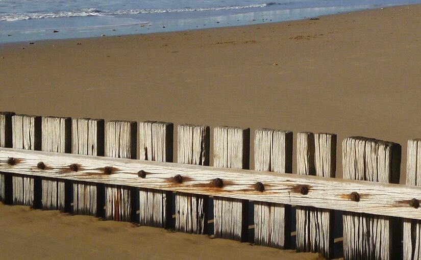 Fence running along a sandy beach